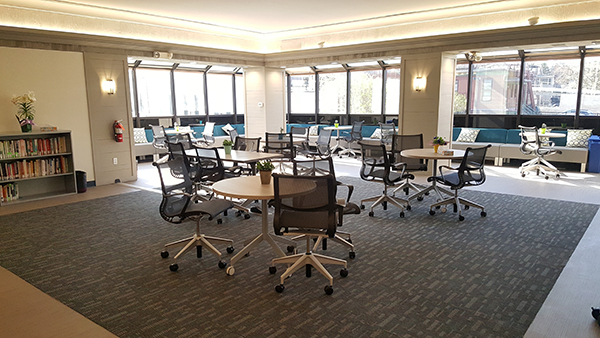 Open office area with tables, chairs, windows